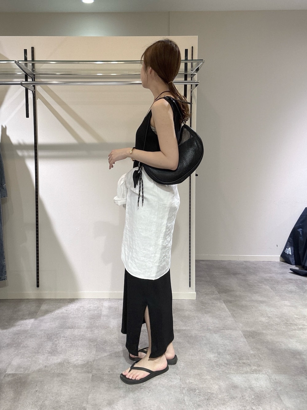 ブラック系のワンピース、ホワイト系のシャツ/ブラウス、ブラック系のハンドバッグを着用したレディースの春コーディネートの2枚目の写真