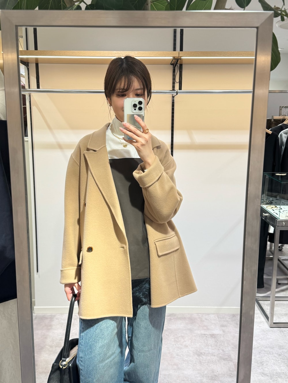 イエロー系のその他アウター、ブルー系のデニムパンツ、ブラウン系のキャミソールを着用したレディースの冬コーディネートの2枚目の写真