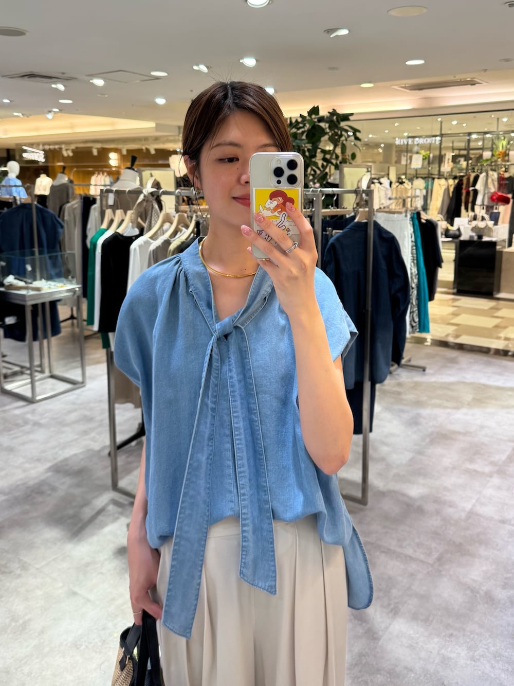 ブルー系のシャツ/ブラウス、ベージュ系のスラックス、ブラック系のサンダルを着用したレディースの夏コーディネートの2枚目の写真