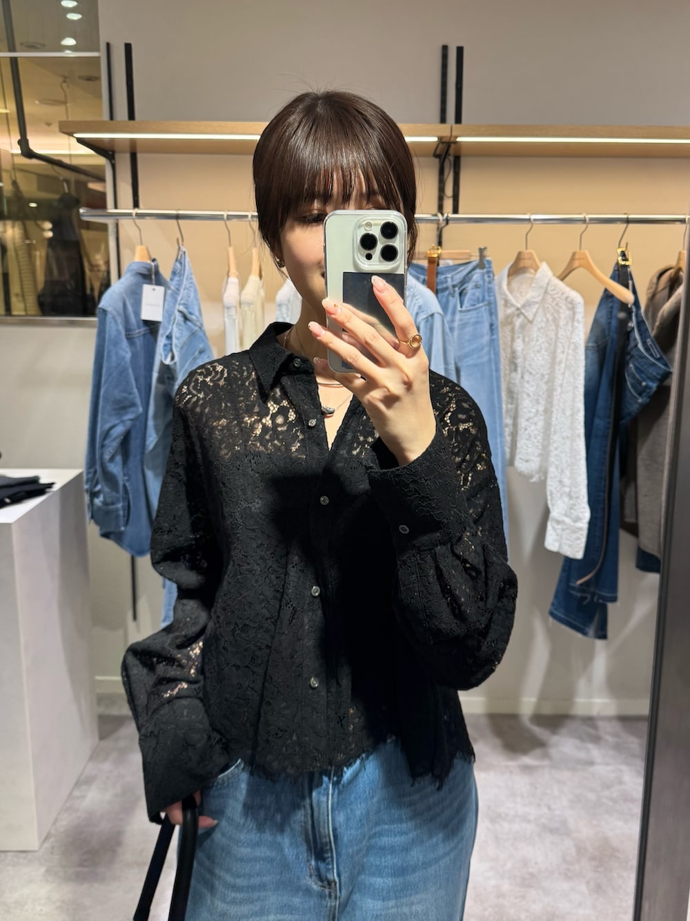 ブラック系のハンドバッグ、ブルー系のデニムパンツ、ブラック系のシャツ/ブラウスを着用したレディースの冬コーディネートの3枚目の写真