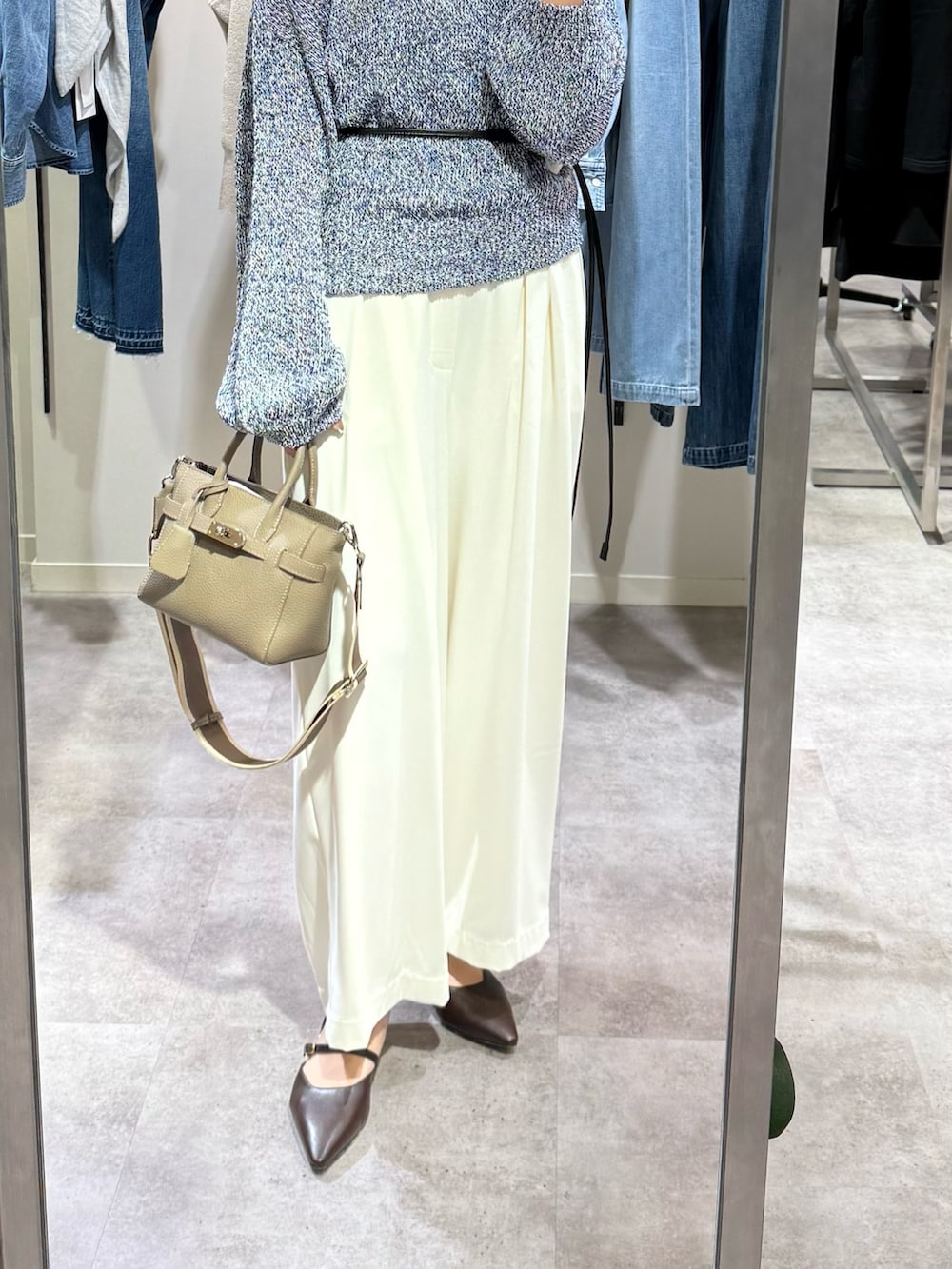 ブルー系のニット/セーター、ホワイト系のスラックス、グレー系のトートバッグを着用したレディースの冬コーディネートの2枚目の写真