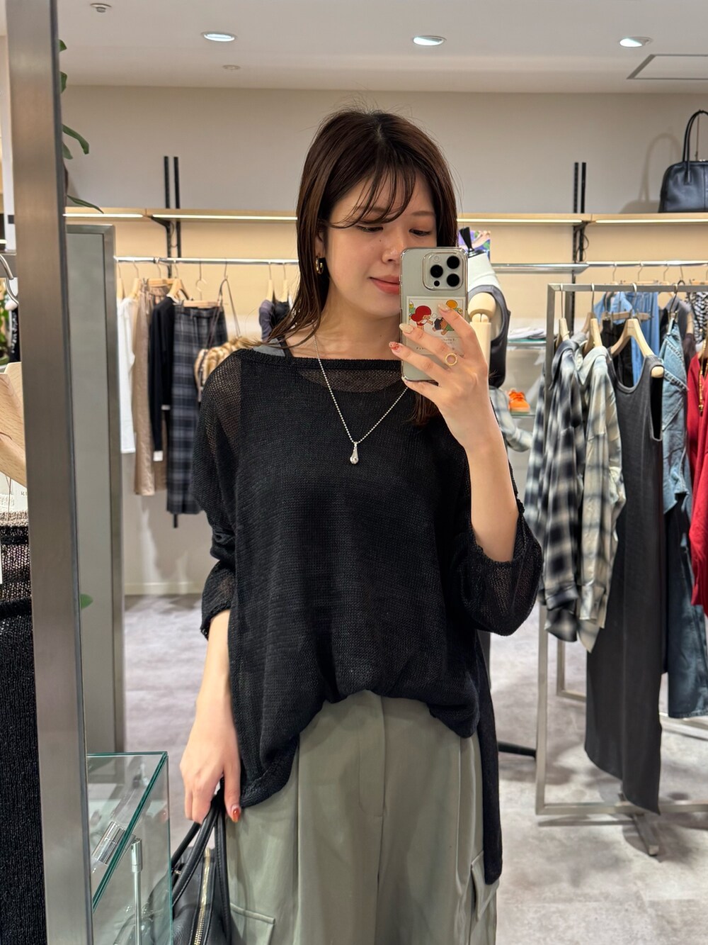 グリーン系のカーゴパンツ、ブラウン系のパンプス、ブラック系のニット/セーターを着用したレディースの夏コーディネートの2枚目の写真