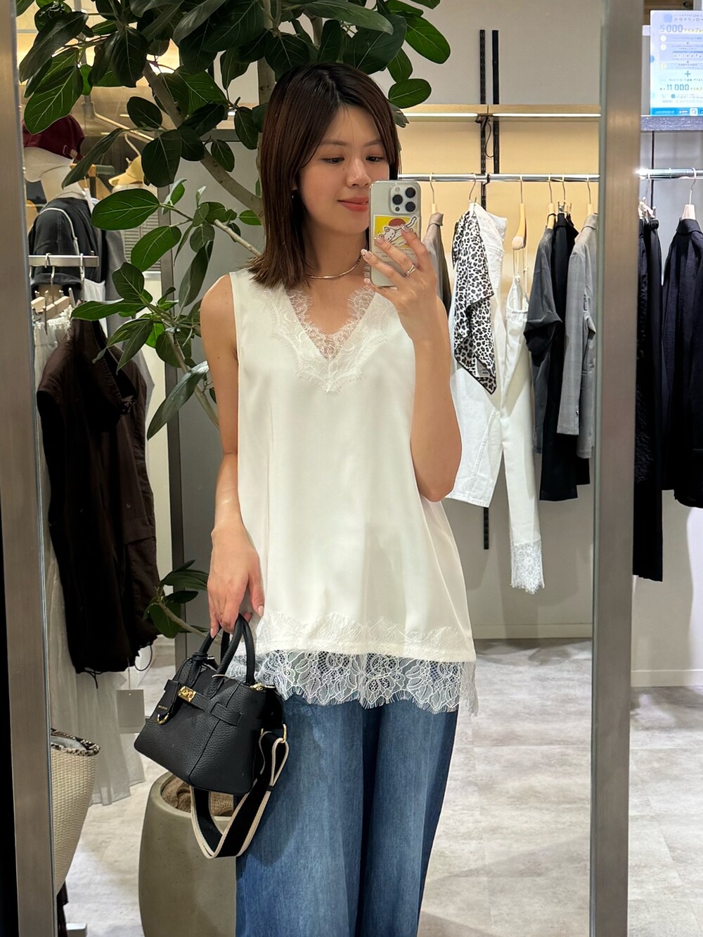 ホワイト系のシャツ/ブラウス、ブルー系のデニムパンツ、ブラック系のトートバッグを着用したレディースの夏コーディネートの2枚目の写真