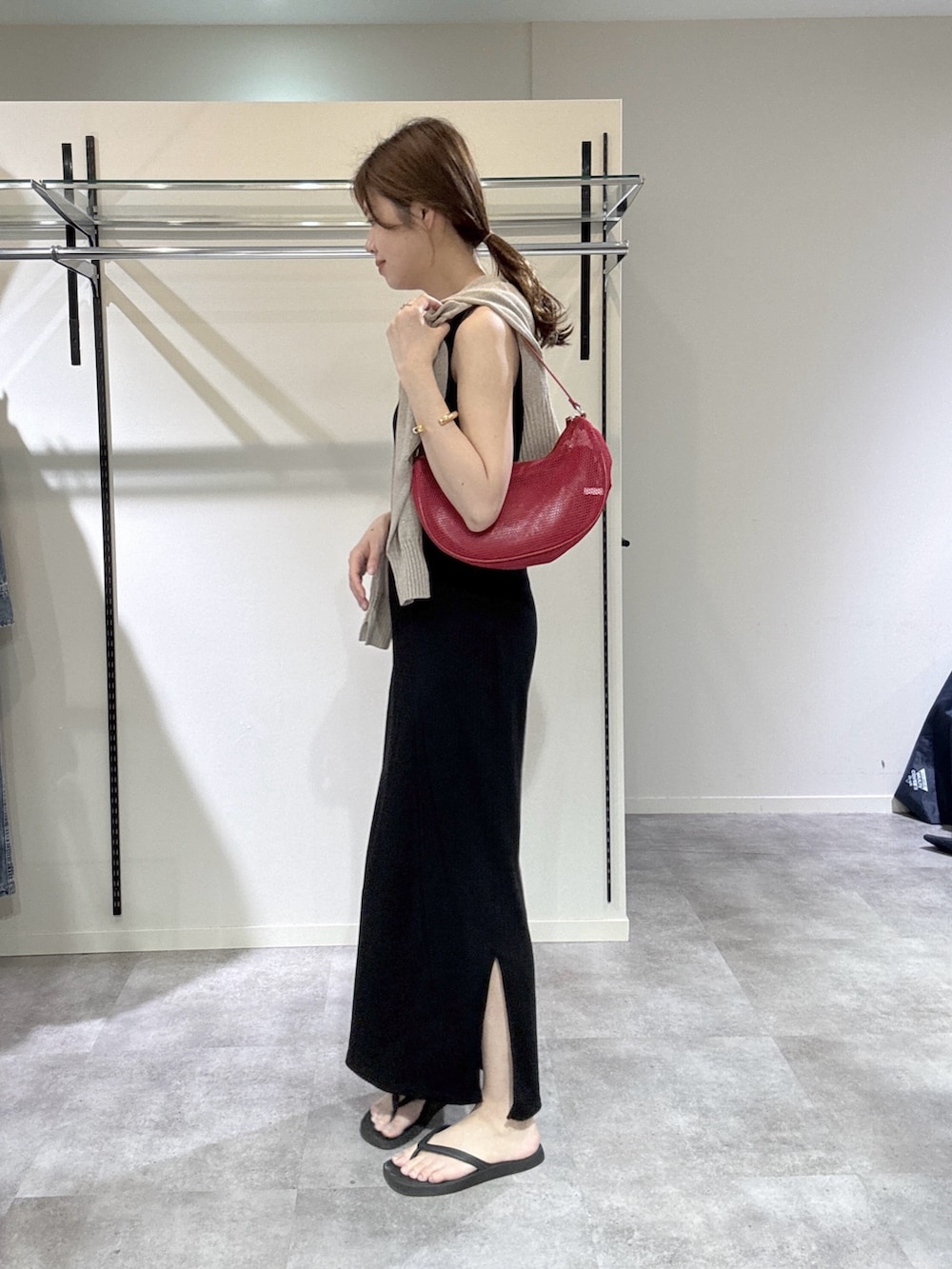 ブラック系のワンピース、ブラウン系のカーディガン/ボレロ、レッド系のハンドバッグを着用したレディースの春コーディネートの2枚目の写真