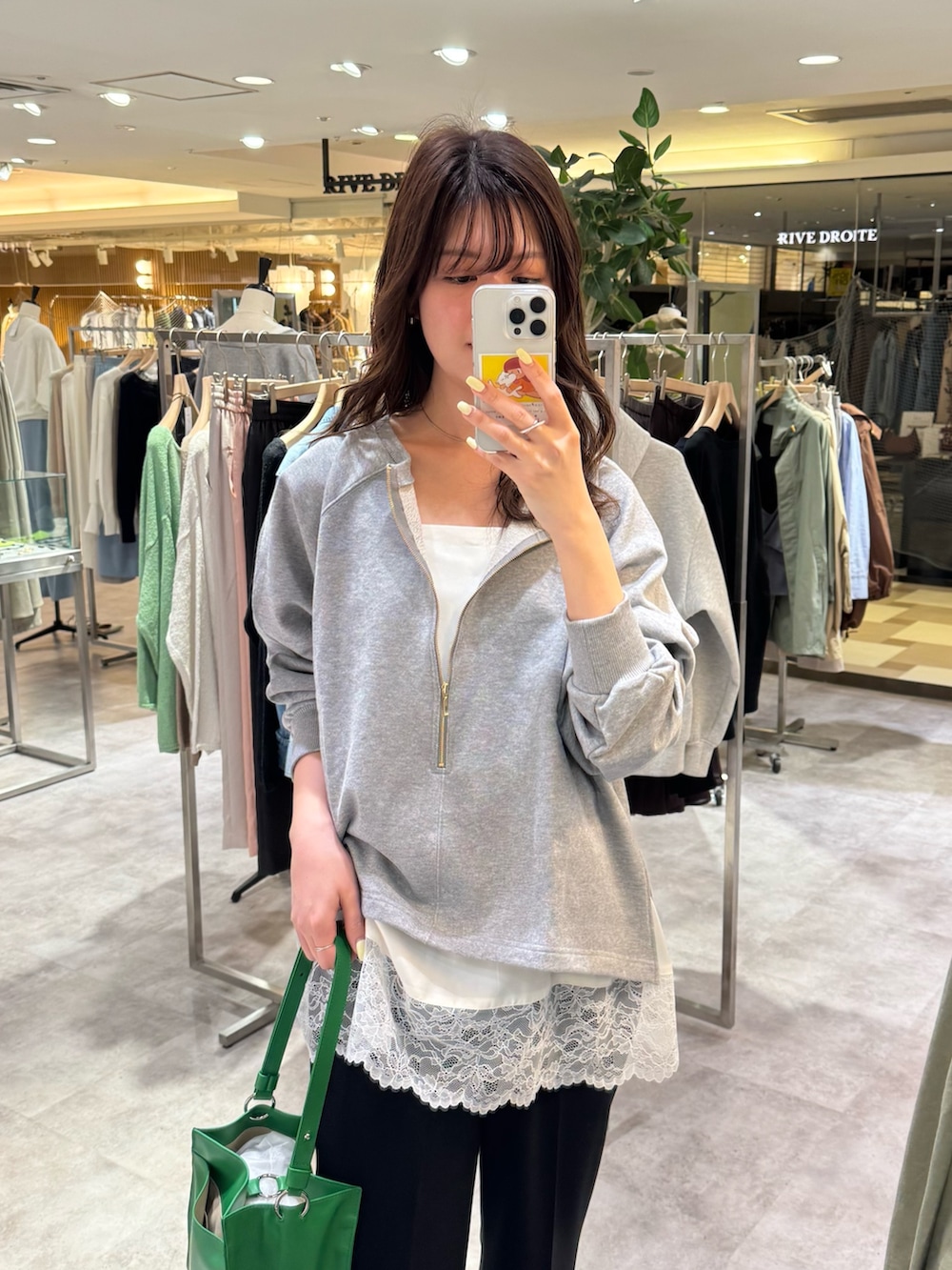 グレー系のスウェット、ホワイト系のキャミソール、ブラック系のその他パンツを着用したレディースの春コーディネートの2枚目の写真