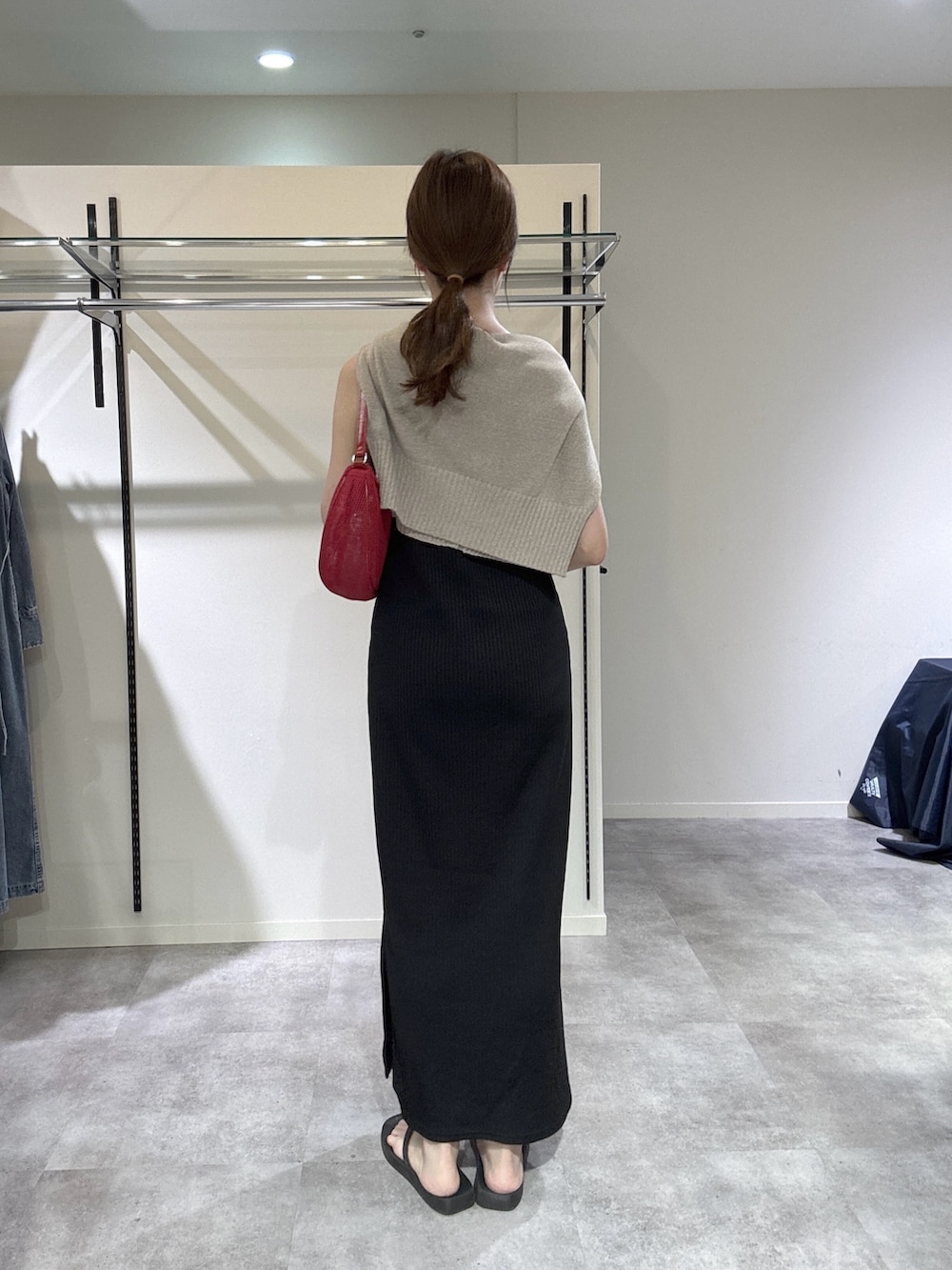 ブラック系のワンピース、ブラウン系のカーディガン/ボレロ、レッド系のハンドバッグを着用したレディースの春コーディネートの3枚目の写真