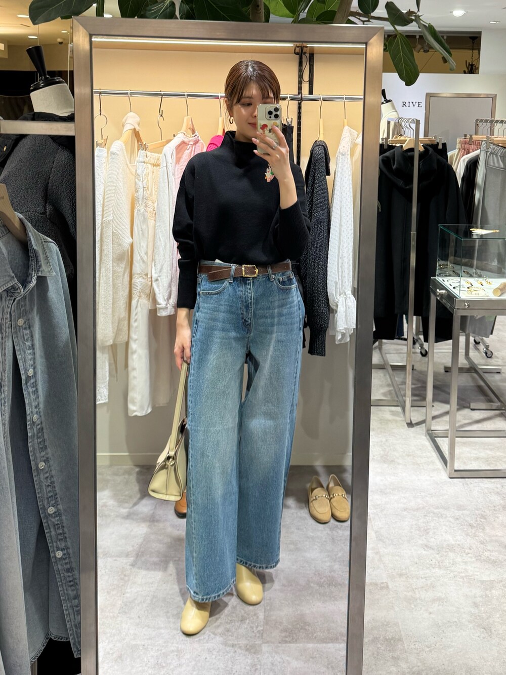 ブラウン系のその他アウター、ブルー系のデニムパンツ、ブラック系のニット/セーターを着用したレディースの冬コーディネートの3枚目の写真