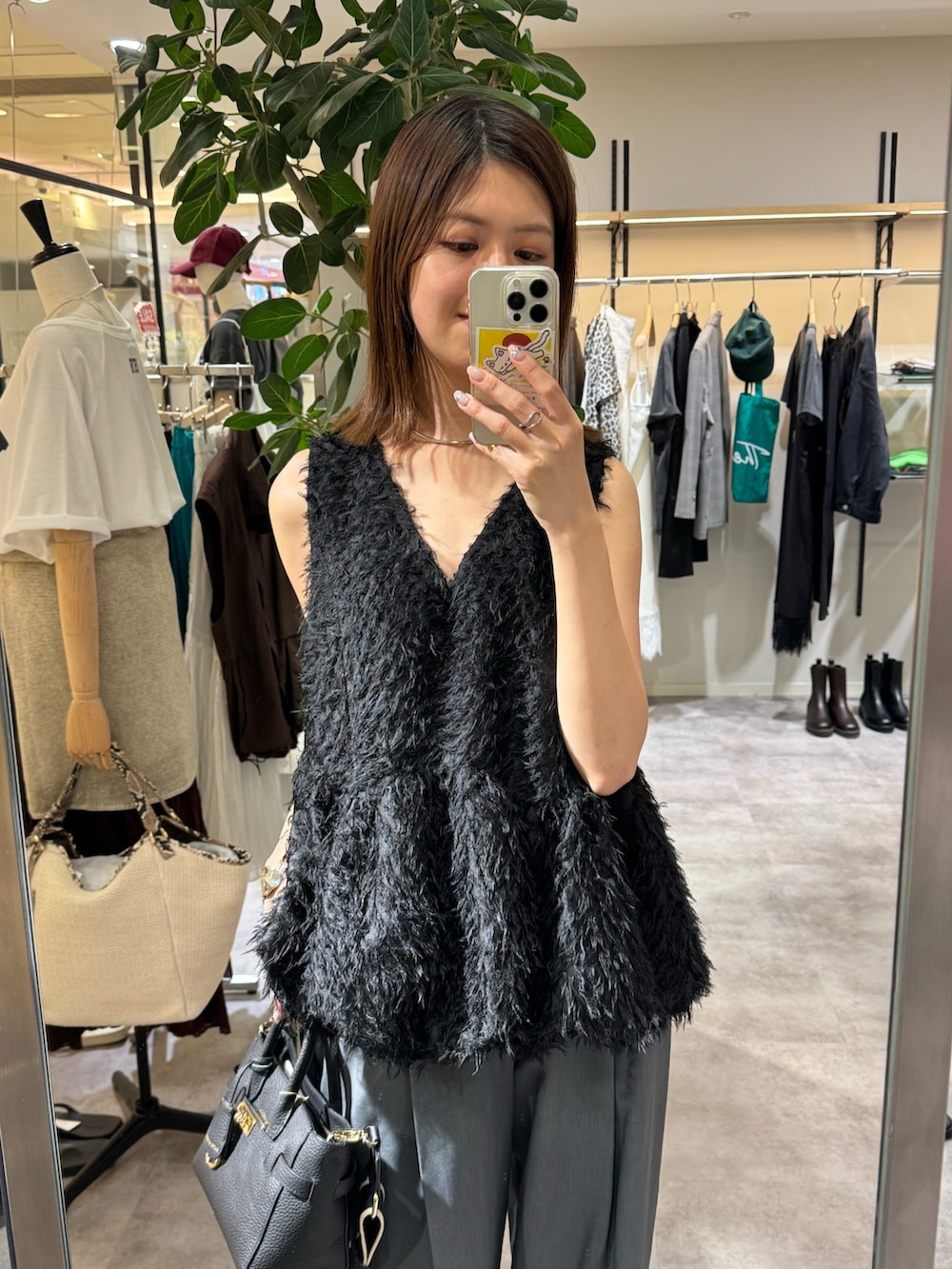 グレー系のスラックス、ブラック系のシャツ/ブラウス、ブラック系のトートバッグを着用したレディースの夏コーディネートの2枚目の写真