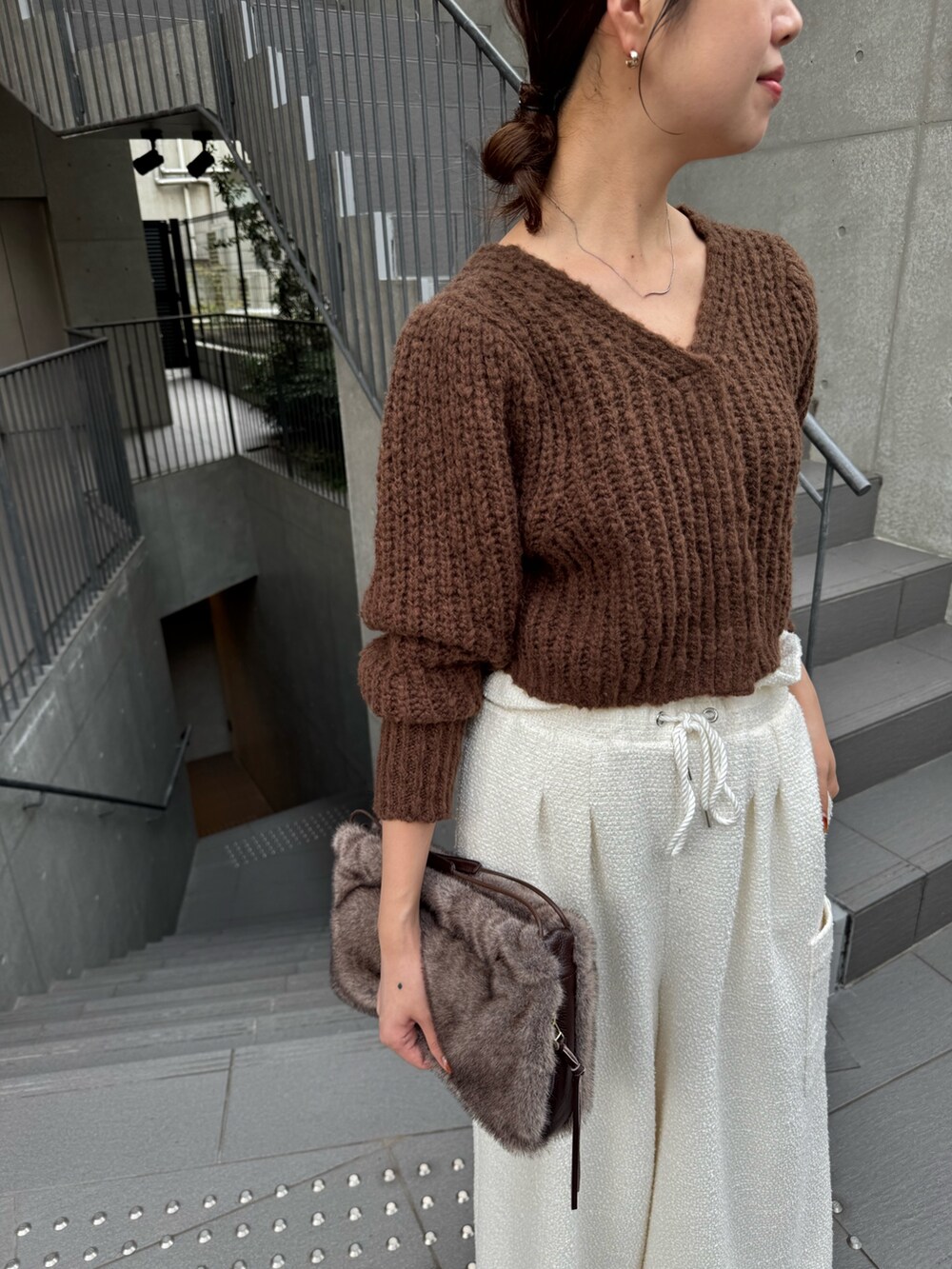 ブラウン系のハンドバッグ、ホワイト系のその他パンツ、ブラウン系のカーディガン/ボレロを着用したレディースの秋コーディネートの2枚目の写真