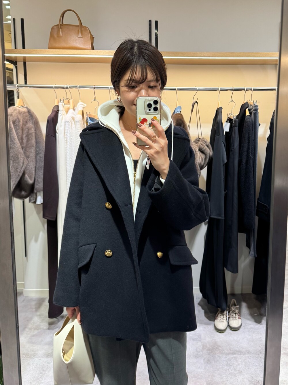 ブルー系のピーコート、グレー系のその他パンツ、ブラック系のブーツを着用したレディースの秋コーディネートの2枚目の写真