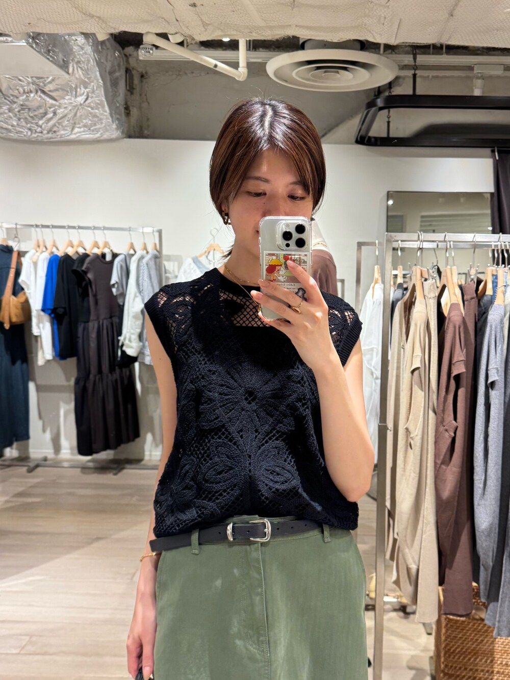 グリーン系のスカート、ブラック系のニット/セーター、ブラック系のキャミソールを着用したレディースの夏コーディネートの2枚目の写真