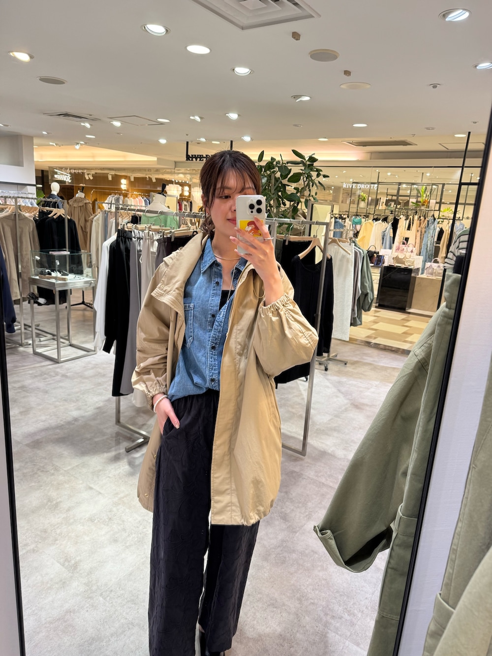 ベージュ系のその他アウター、ブラック系のその他パンツ、ホワイト系のショルダーバッグを着用したレディースの春コーディネートの2枚目の写真