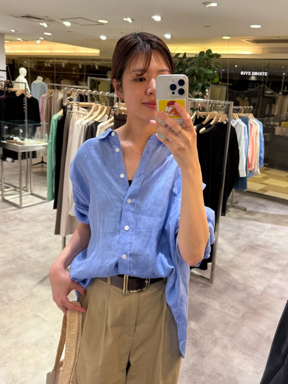 ブルー系のシャツ/ブラウス、ベージュ系のチノパンツ、ホワイト系のその他シューズを着用したレディースの春コーディネートの2枚目の写真