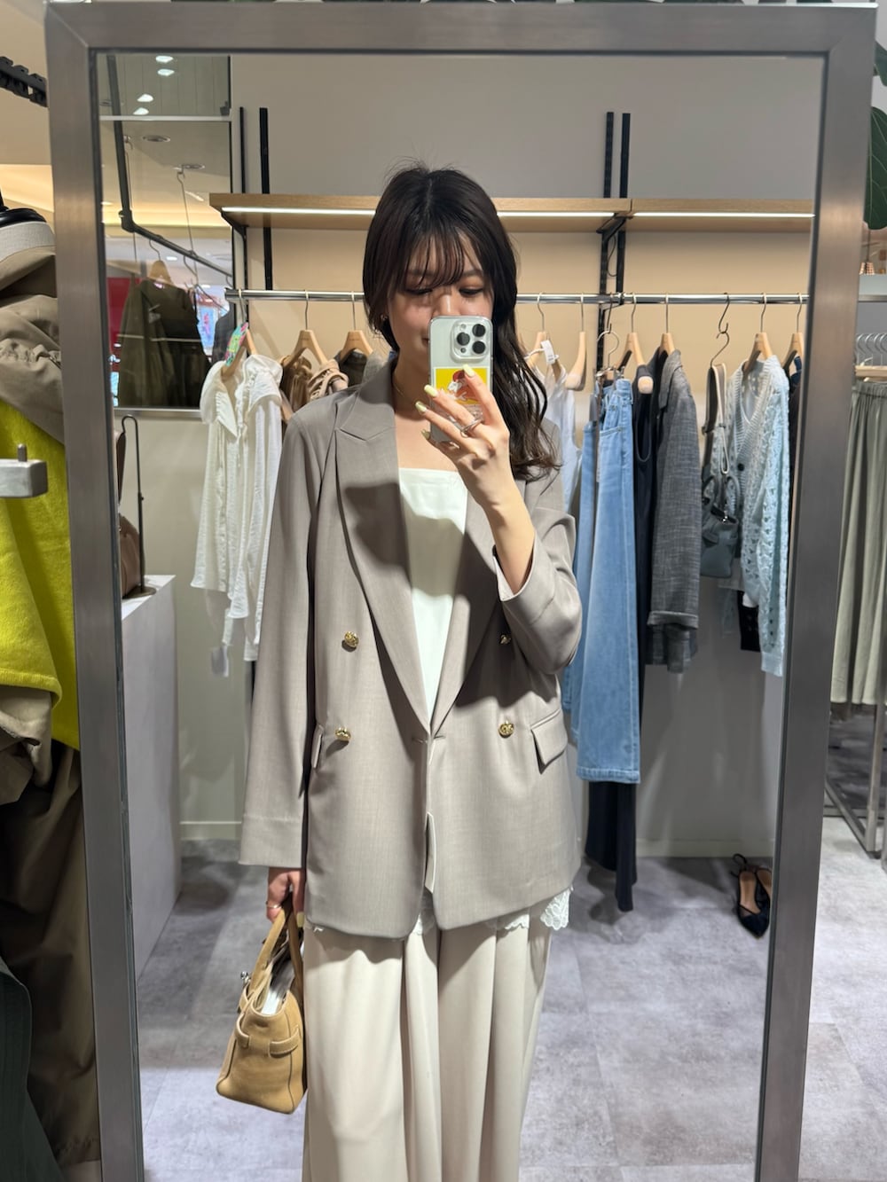 ベージュ系のその他パンツ、ブラウン系のテーラードジャケット、ホワイト系のキャミソールを着用したレディースの春コーディネートの2枚目の写真