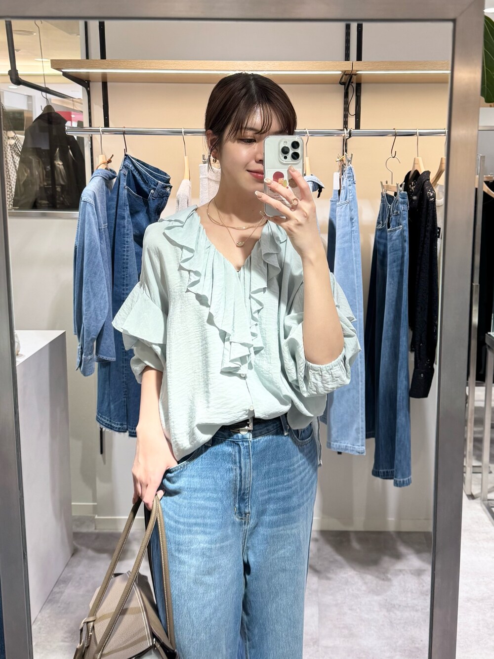 ブルー系のシャツ/ブラウス、ブルー系のデニムパンツ、ブラウン系のトートバッグを着用したレディースの冬コーディネートの2枚目の写真