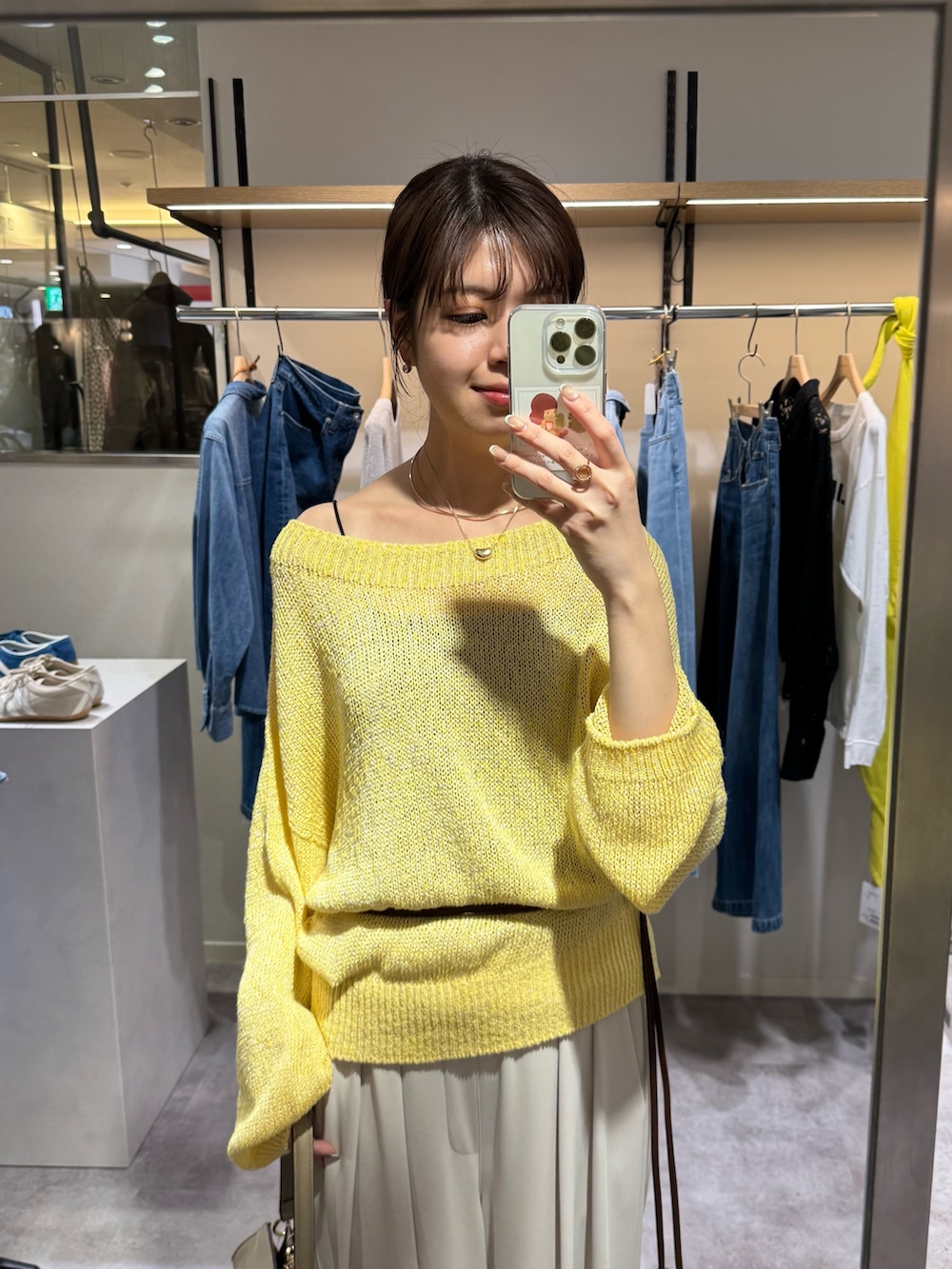 イエロー系のニット/セーター、グレー系のスラックス、ブラウン系のベルトを着用したレディースの冬コーディネートの2枚目の写真