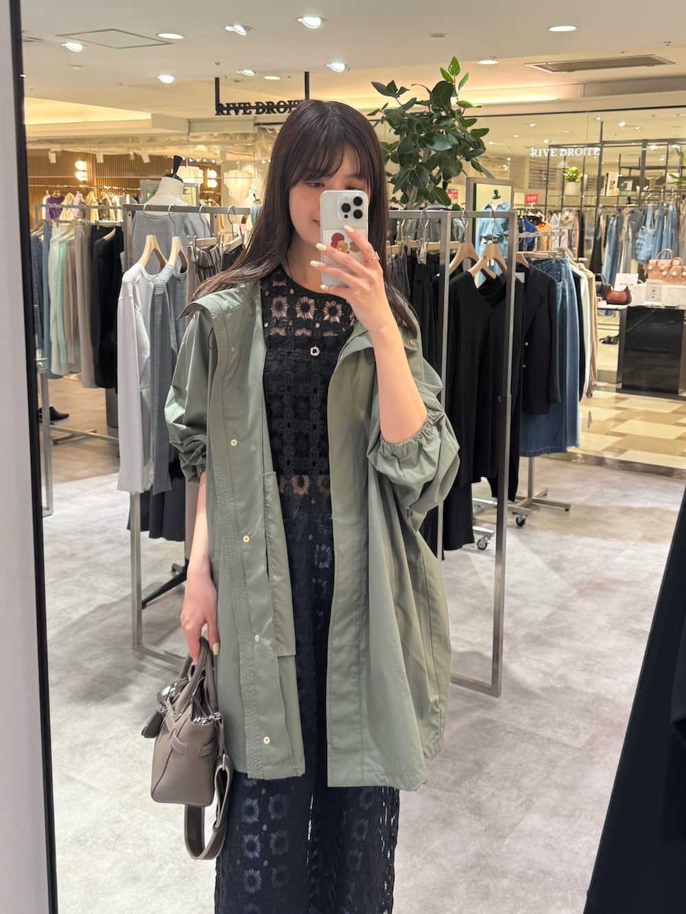 グリーン系のその他アウター、ブラック系のワンピース、ブルー系のデニムパンツを着用したレディースの冬コーディネートの2枚目の写真