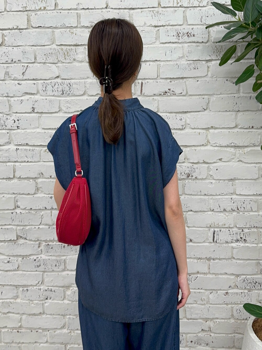 ブルー系のシャツ/ブラウス、ブルー系のその他パンツ、レッド系のハンドバッグを着用したレディースの夏コーディネートの3枚目の写真
