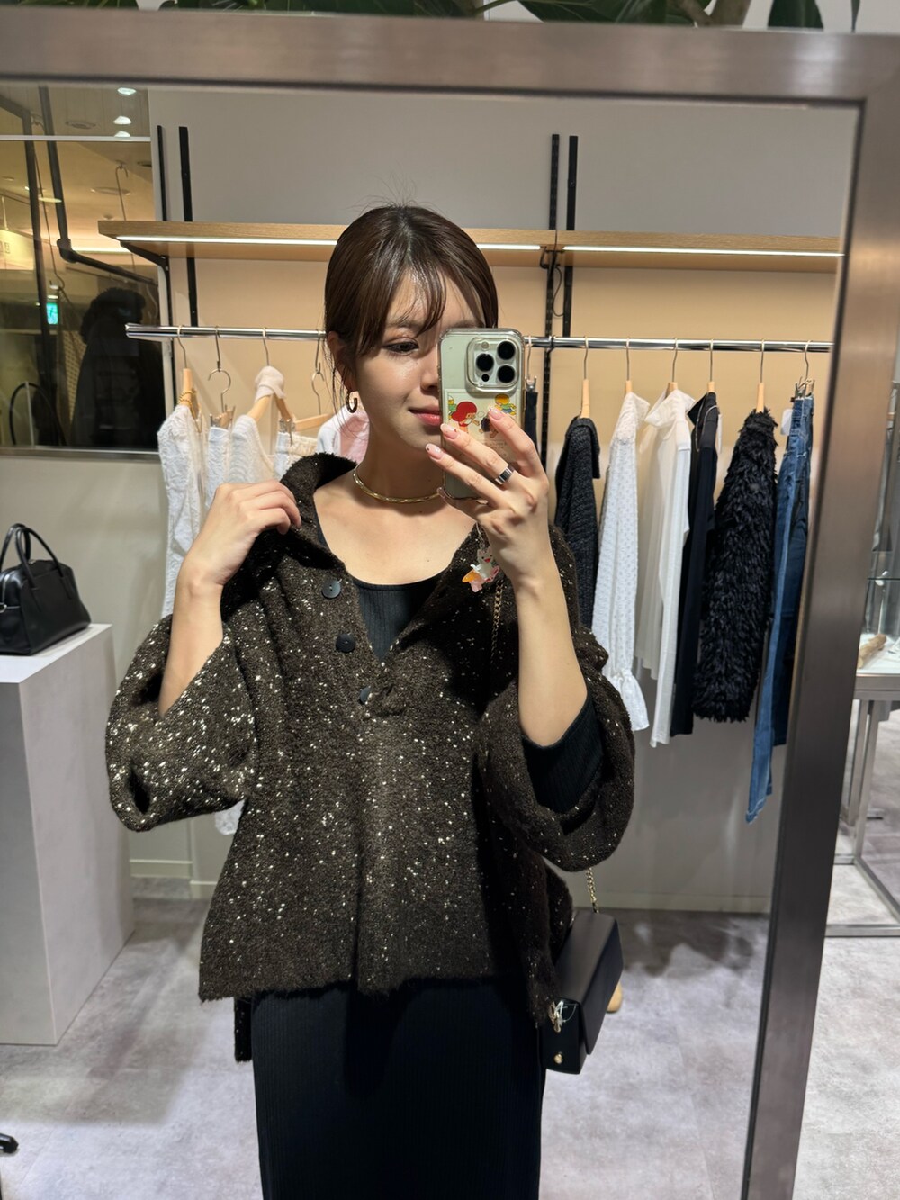 ブラウン系のニット/セーター、ブラック系のワンピースを着用したレディースの冬コーディネートの2枚目の写真