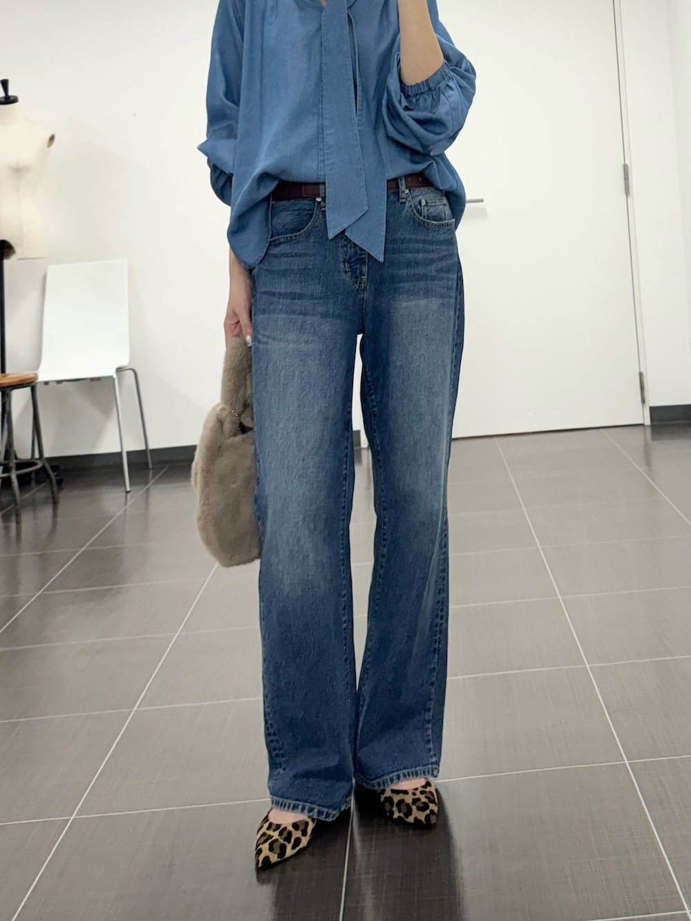 ブルー系のシャツ/ブラウス、ブルー系のデニムパンツ、ベージュ系のパンプスを着用したレディースの秋コーディネートの3枚目の写真