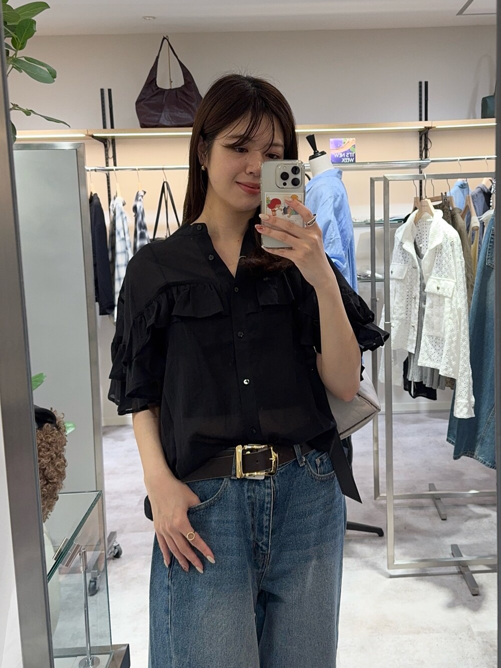 ブラック系のシャツ/ブラウス、ブルー系のデニムパンツ、ブラック系のベルトを着用したレディースの夏コーディネートの2枚目の写真