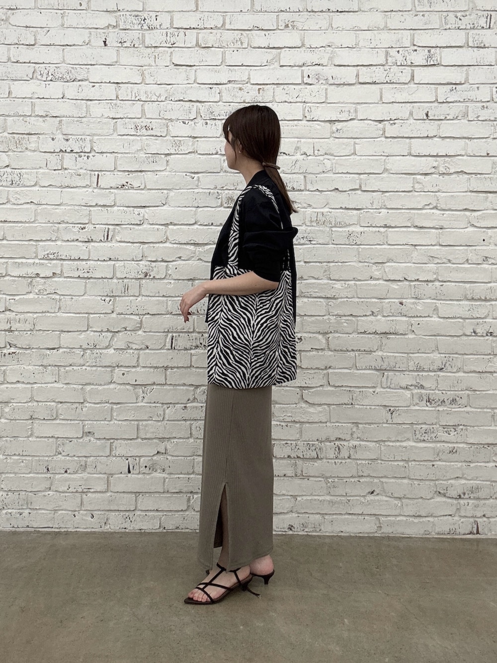 ブラウン系のワンピース、ブラック系のブルゾン、ブラック系のトートバッグを着用したレディースの春コーディネートの2枚目の写真