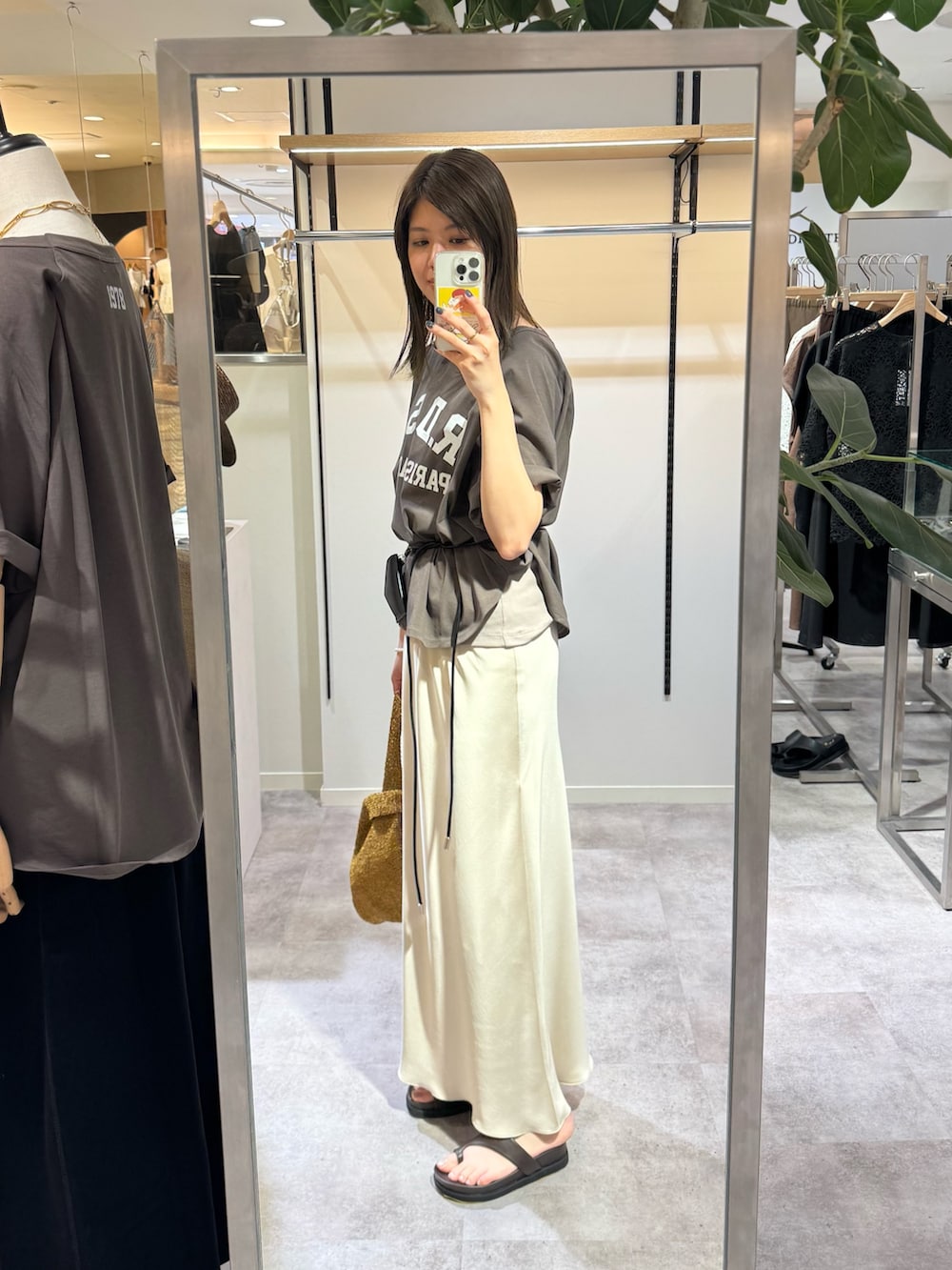 ブラウン系のTシャツ/カットソー、ベージュ系のスカート、ブラウン系のサンダルを着用したレディースの春コーディネートの2枚目の写真