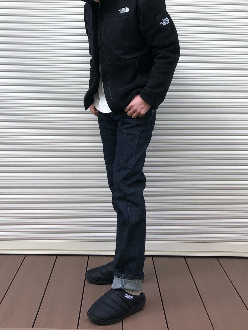 ブラック系のその他アウター、ホワイト系のTシャツ/カットソー、ブルー系のデニムパンツを着用したメンズの冬コーディネートの2枚目の写真