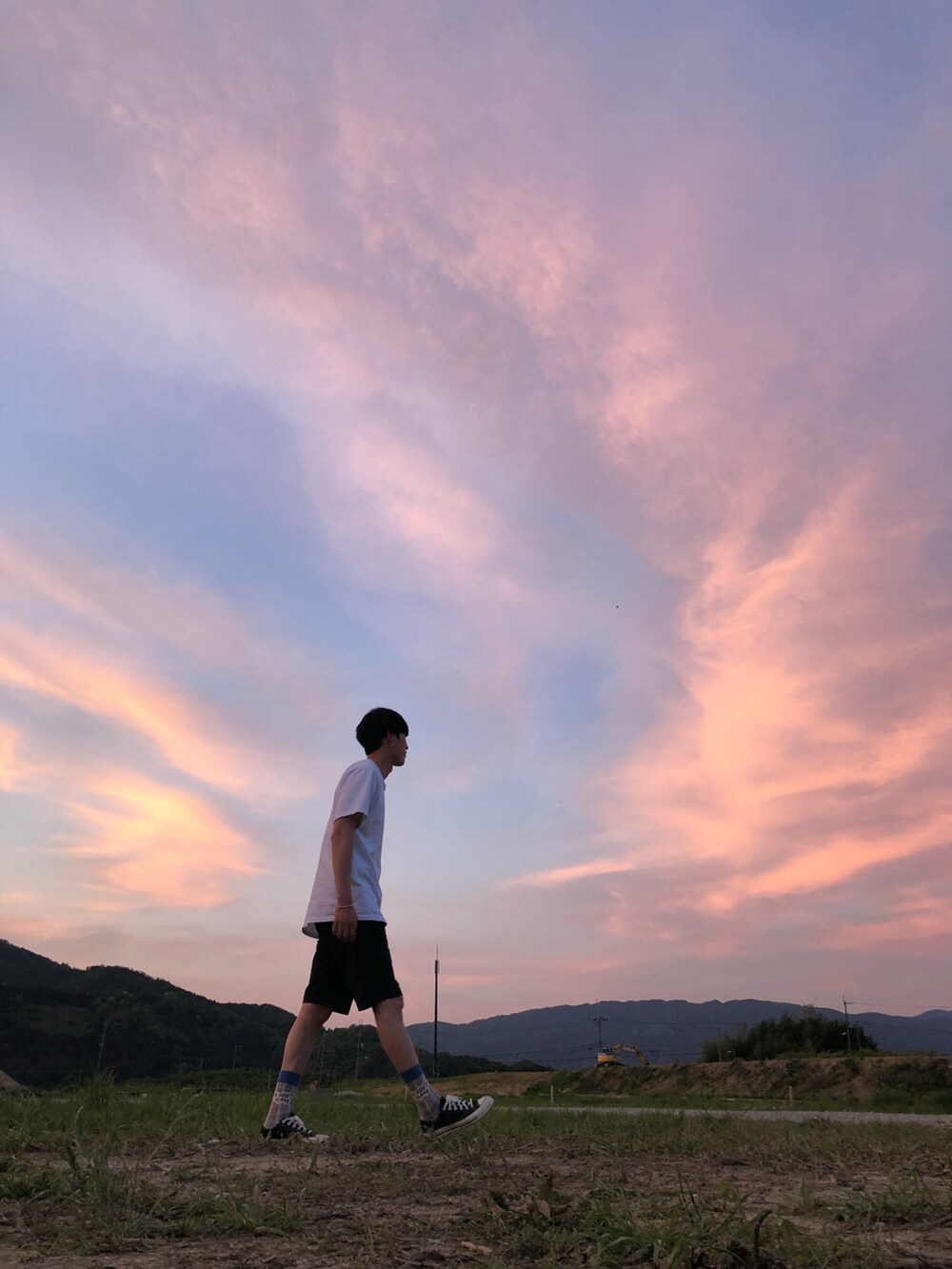 ブルー系のチノパンツ、ホワイト系のTシャツ/カットソー、ブラック系のスニーカーを着用したメンズの春コーディネートの2枚目の写真