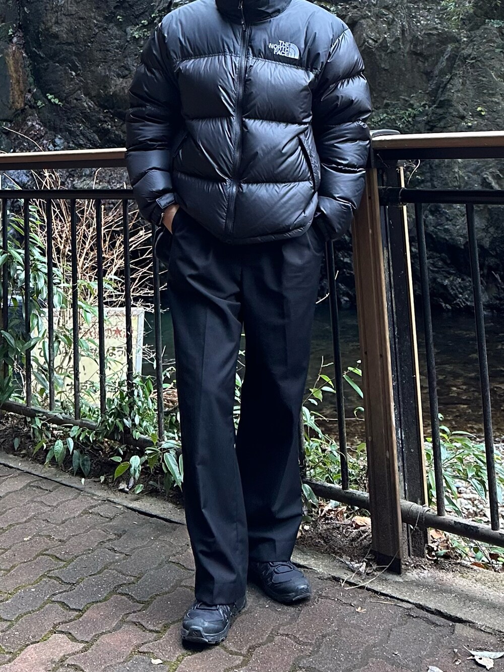 ブラック系のダウンジャケット/コート、ブラック系のスラックス、ブラック系のスニーカーを着用したメンズの冬コーディネートの2枚目の写真