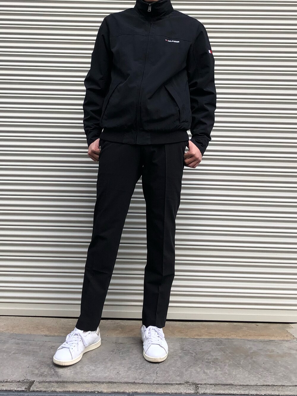 ブラック系のスラックス、ホワイト系のスニーカー、ブラック系のブルゾンを着用したメンズの冬コーディネートの4枚目の写真