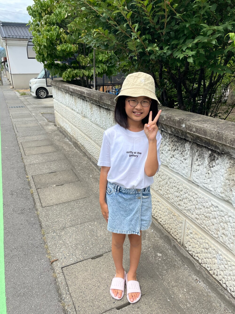 ピンク系のサンダル、ブルー系のデニムスカート、ホワイト系のTシャツ/カットソーを着用したキッズの秋コーディネートの2枚目の写真