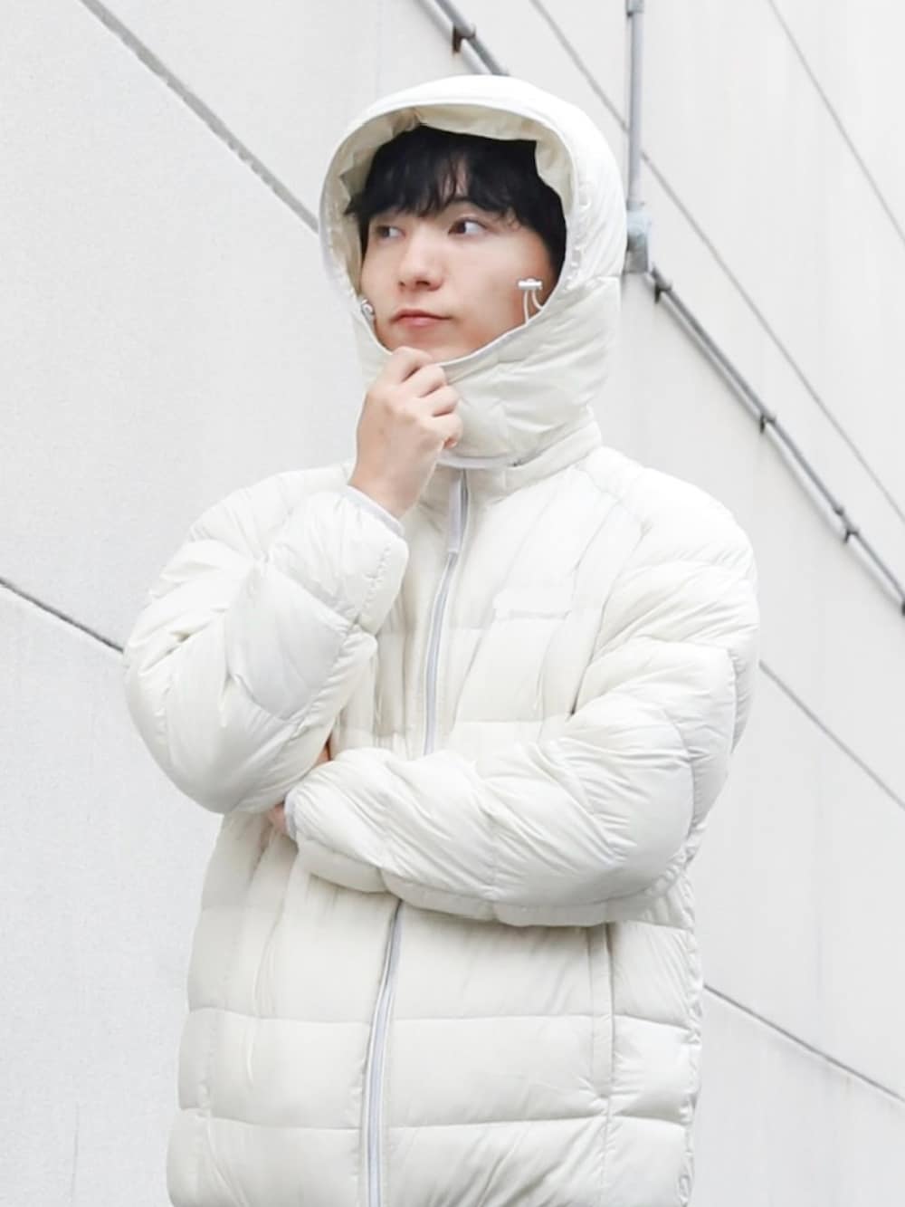 レッド系のニット/セーター、ホワイト系のダウンジャケット/コート、ブラック系のモカシン/デッキシューズを着用したメンズの冬コーディネートの2枚目の写真