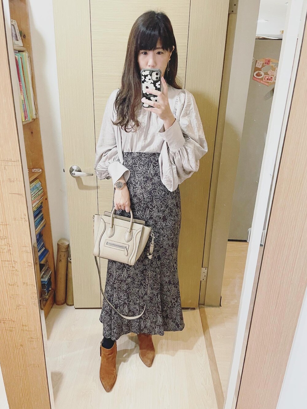 ブラウン系のスカート、ベージュ系のシャツ/ブラウス、ブラウン系のブーツを着用したレディースの冬コーディネートの2枚目の写真