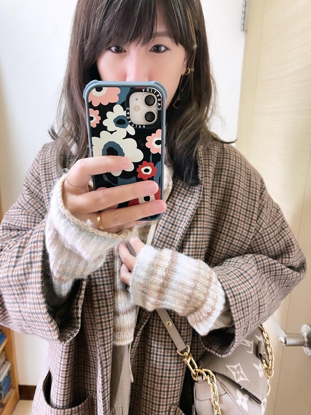 その他のノーカラーコート、グレー系のバッグ、ベージュ系のニット/セーターを着用したレディースの冬コーディネートの3枚目の写真