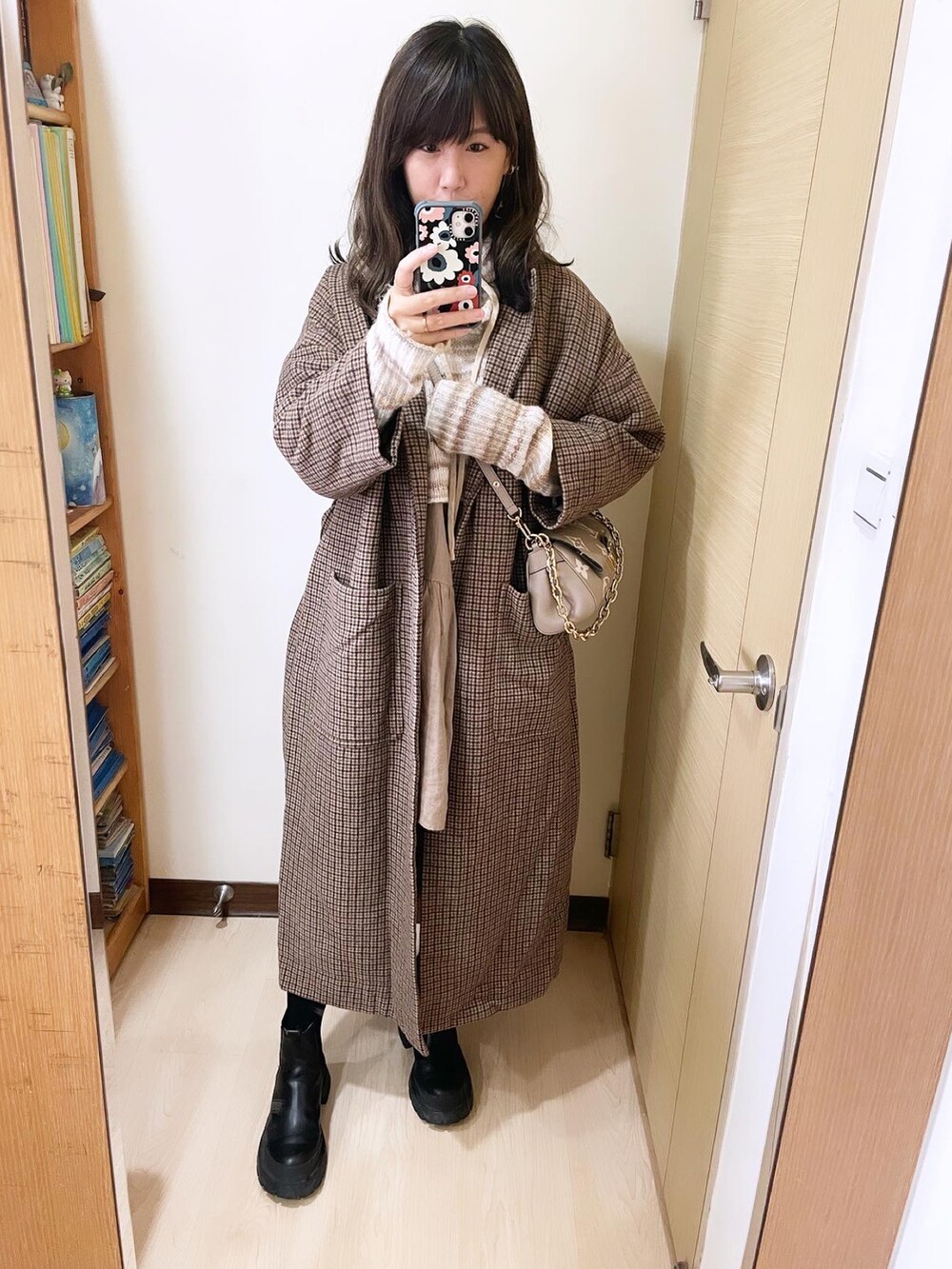 その他のノーカラーコート、グレー系のバッグ、ベージュ系のニット/セーターを着用したレディースの冬コーディネートの2枚目の写真