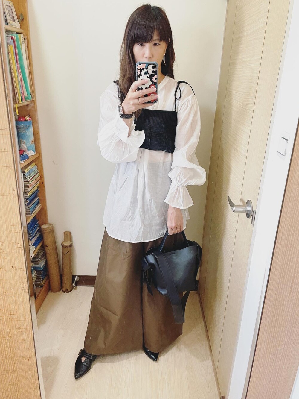 ブラック系のシャツ/ブラウス、ブラック系のトートバッグ、ブラック系のシューズを着用したレディースの夏コーディネートの2枚目の写真