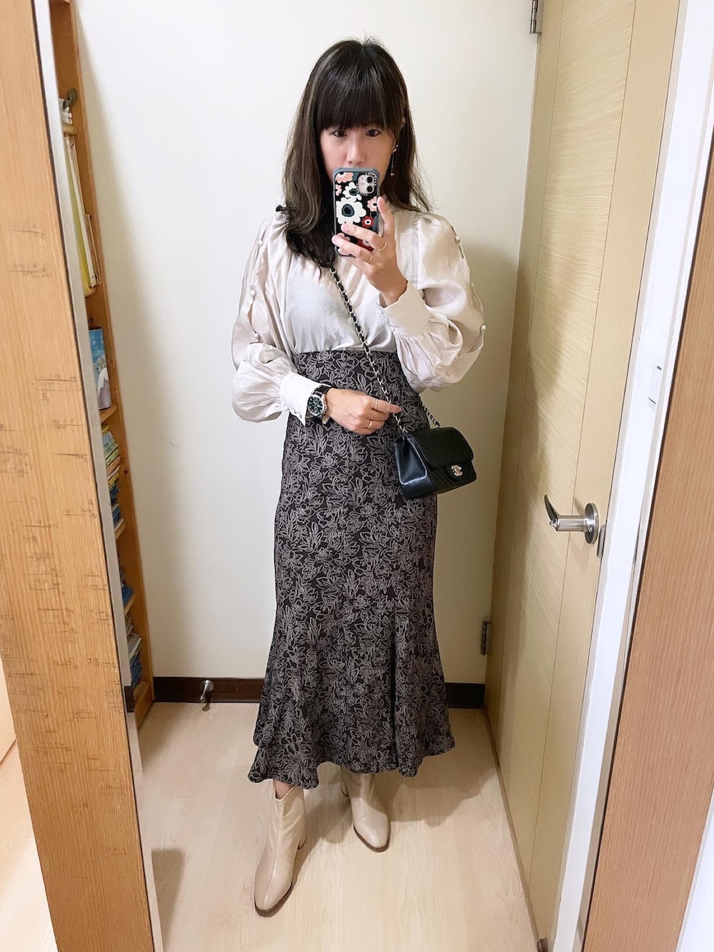 ブラウン系のスカート、ベージュ系のシューズ、ブラック系のバッグを着用したレディースの冬コーディネートの2枚目の写真