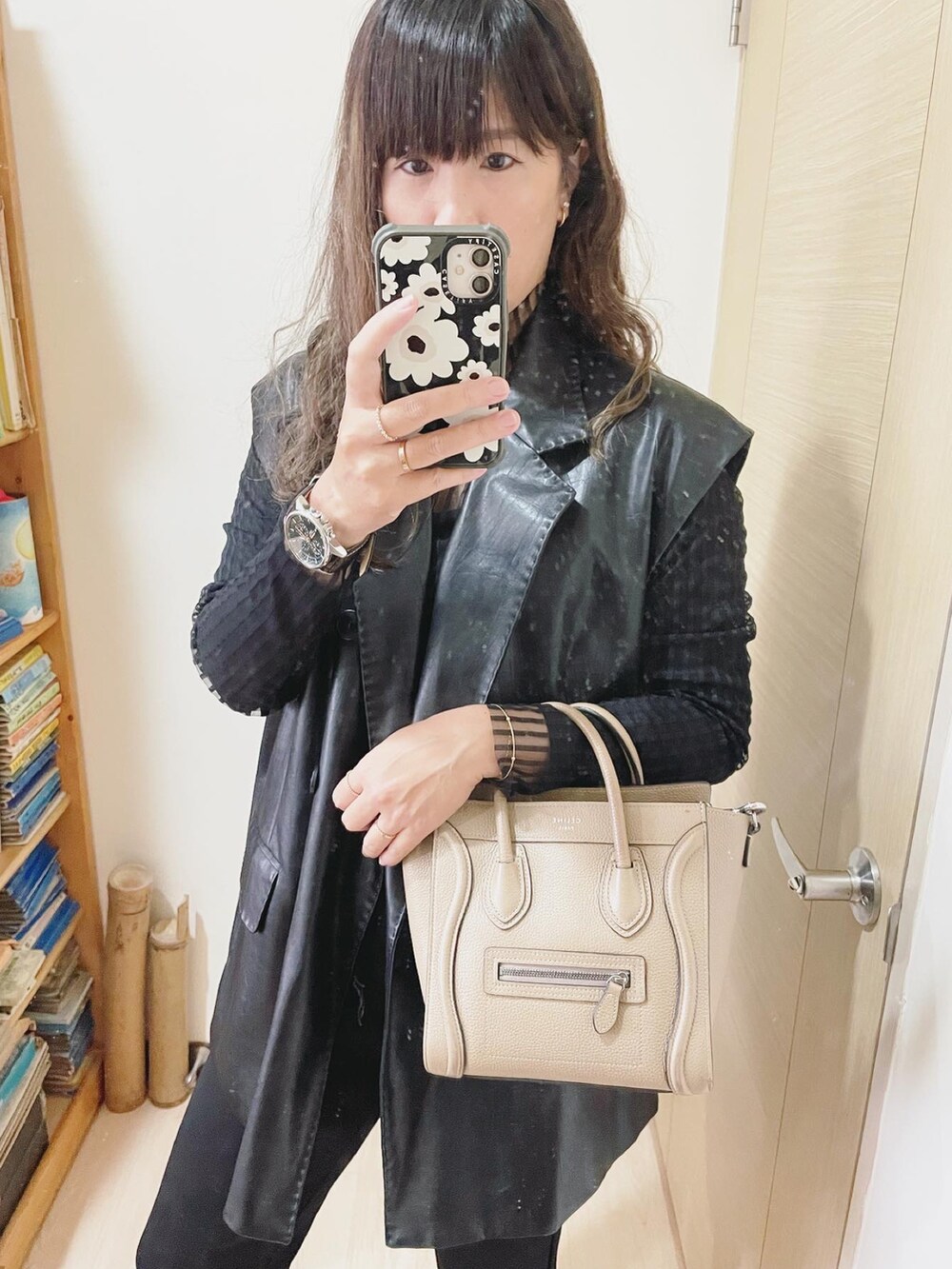 ベージュ系のバッグ、ブラック系のシューズ、グリーン系のアナログ腕時計を着用したレディースの春コーディネートの2枚目の写真