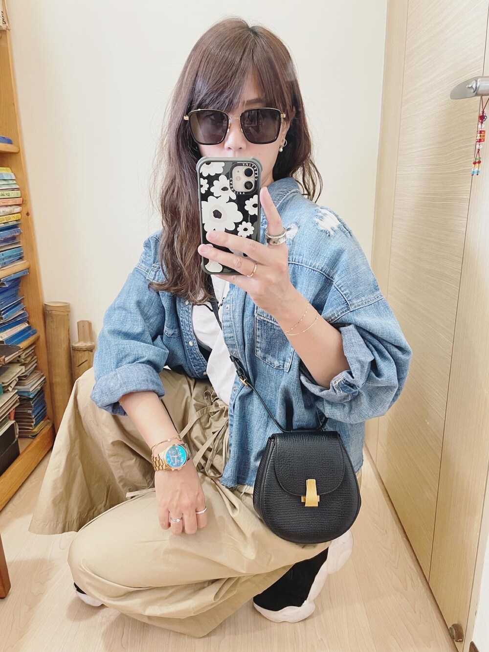 ブラック系のスニーカー、ベージュ系のパンツ、ブラック系のバッグを着用したレディースの春コーディネートの2枚目の写真