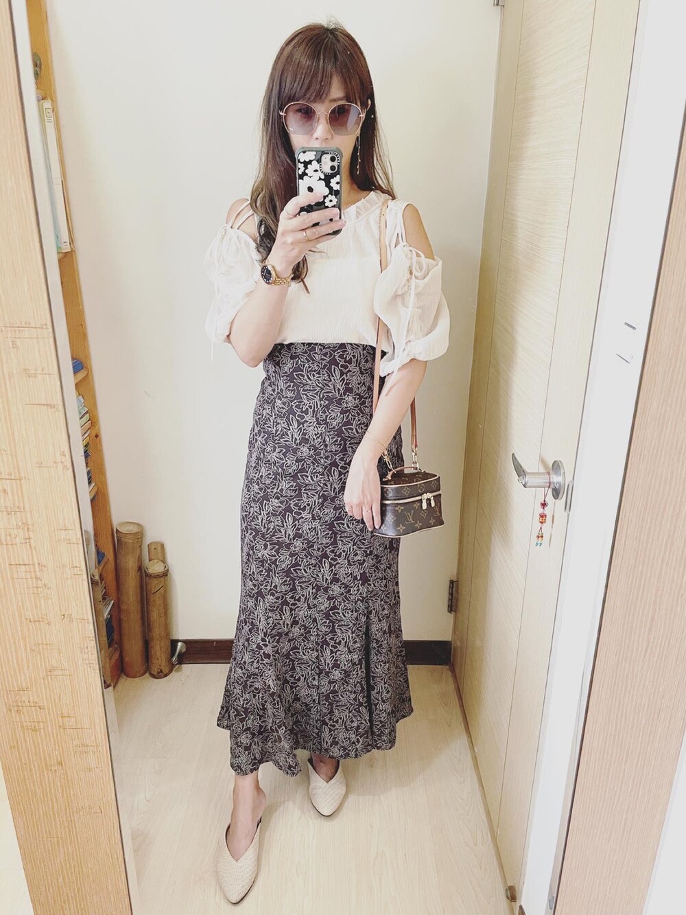 ブラック系のシャツ/ブラウス、ブラウン系のスカート、ブラウン系のバッグを着用したレディースの夏コーディネートの2枚目の写真