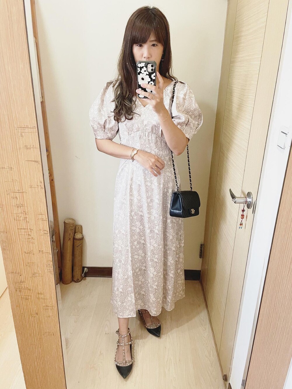 ベージュ系のワンピース、ブラック系のバッグ、ブラック系のシューズを着用したレディースの夏コーディネートの2枚目の写真