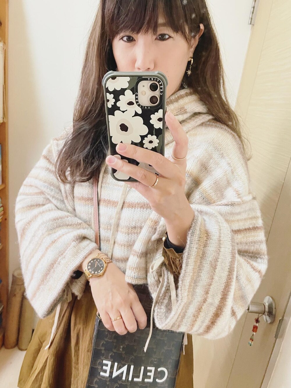 ブラウン系のワンピース、ブラウン系のバッグ、ベージュ系のニット/セーターを着用したレディースの春コーディネートの2枚目の写真