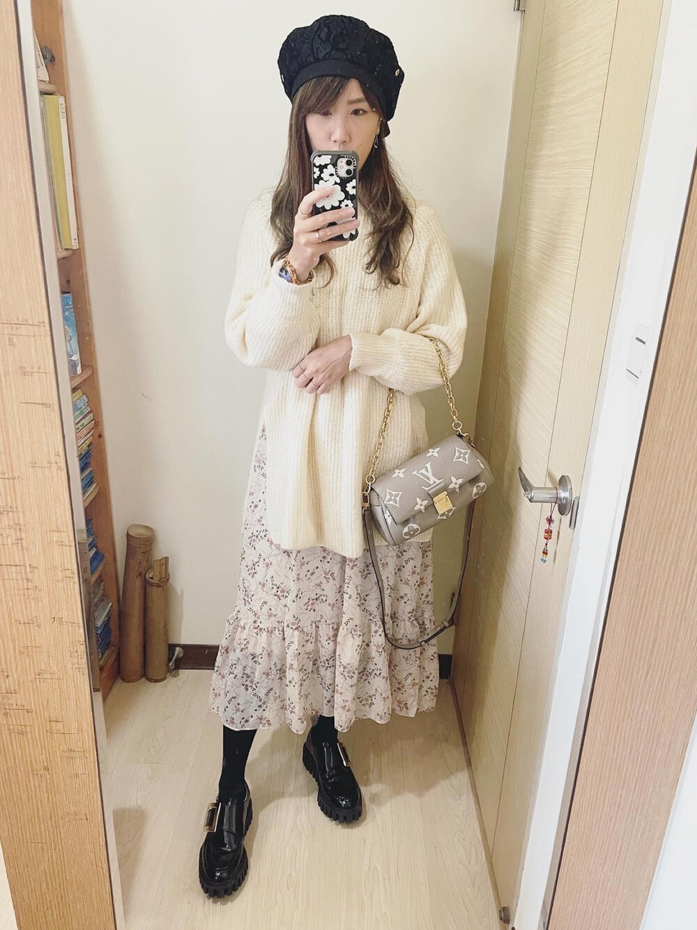 グレー系のバッグ、ホワイト系のニット/セーター、ブラック系のシューズを着用したレディースの冬コーディネートの2枚目の写真