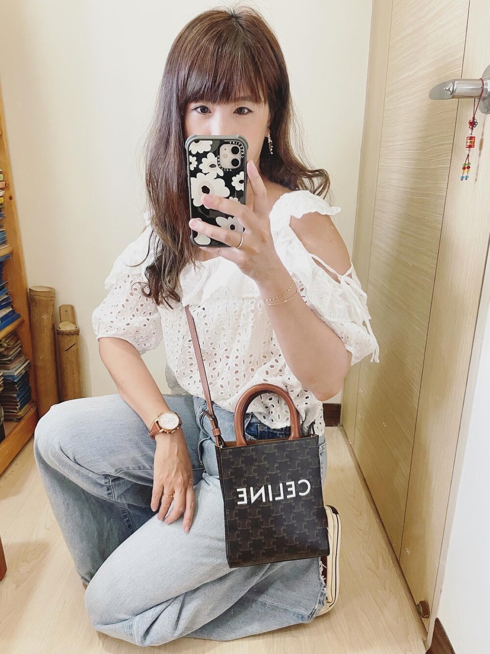 ブルー系のデニムパンツ、ホワイト系のシャツ/ブラウス、ブラウン系のバッグを着用したレディースの夏コーディネートの3枚目の写真