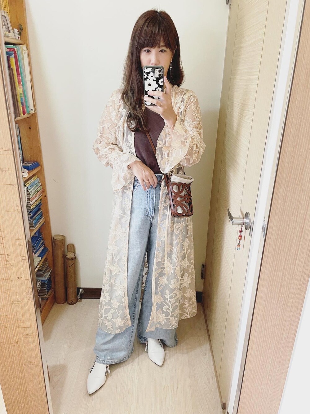 ブルー系のデニムパンツ、ブラウン系のトップス、ベージュ系のワンピース/ドレスを着用したレディースの夏コーディネートの2枚目の写真