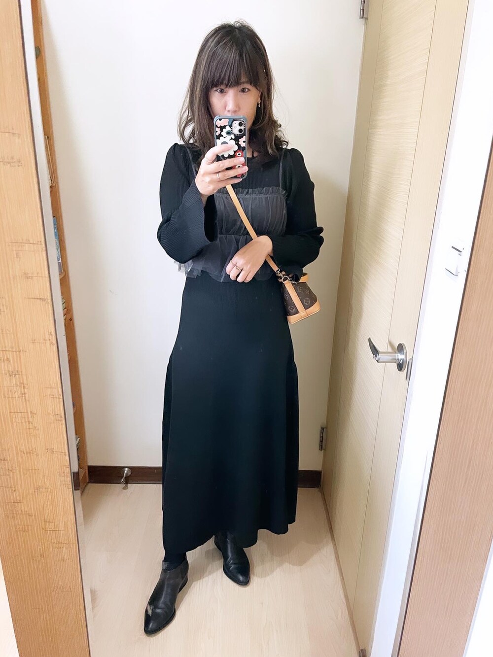 その他のバッグ、ブラック系のブーツ、ブラック系のワンピースを着用したレディースの冬コーディネートの2枚目の写真