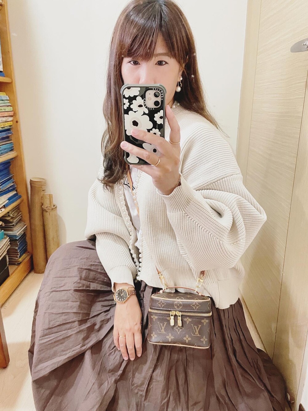 ブラウン系のスカート、ベージュ系のカーディガン/ボレロ、ホワイト系のTシャツ/カットソーを着用したレディースの冬コーディネートの2枚目の写真