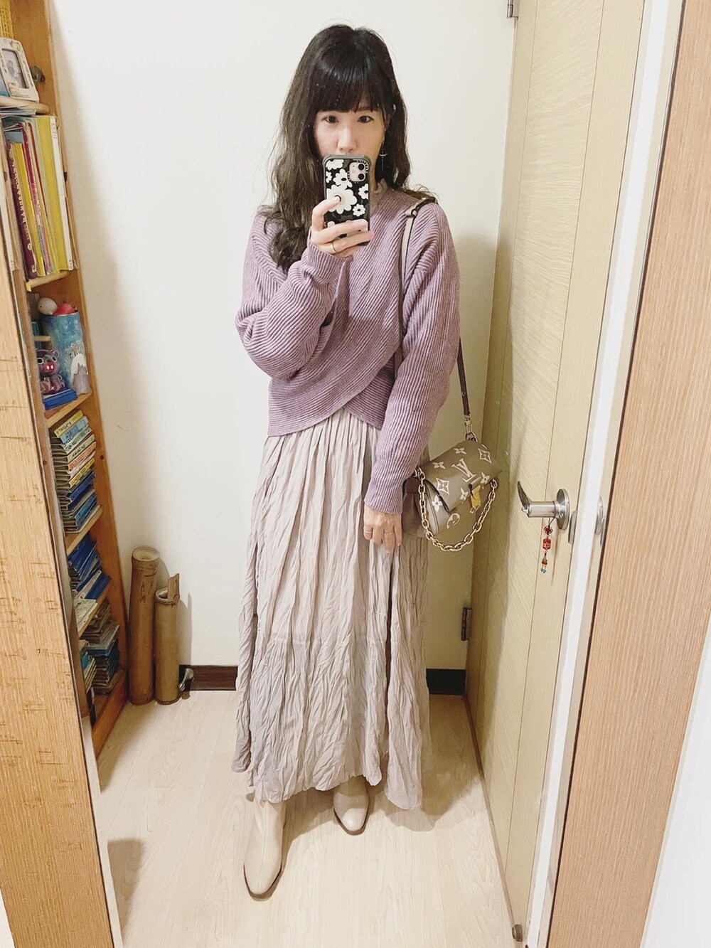 パープル系のニット/セーター、ベージュ系のワンピース、グレー系のバッグを着用したレディースの冬コーディネートの2枚目の写真