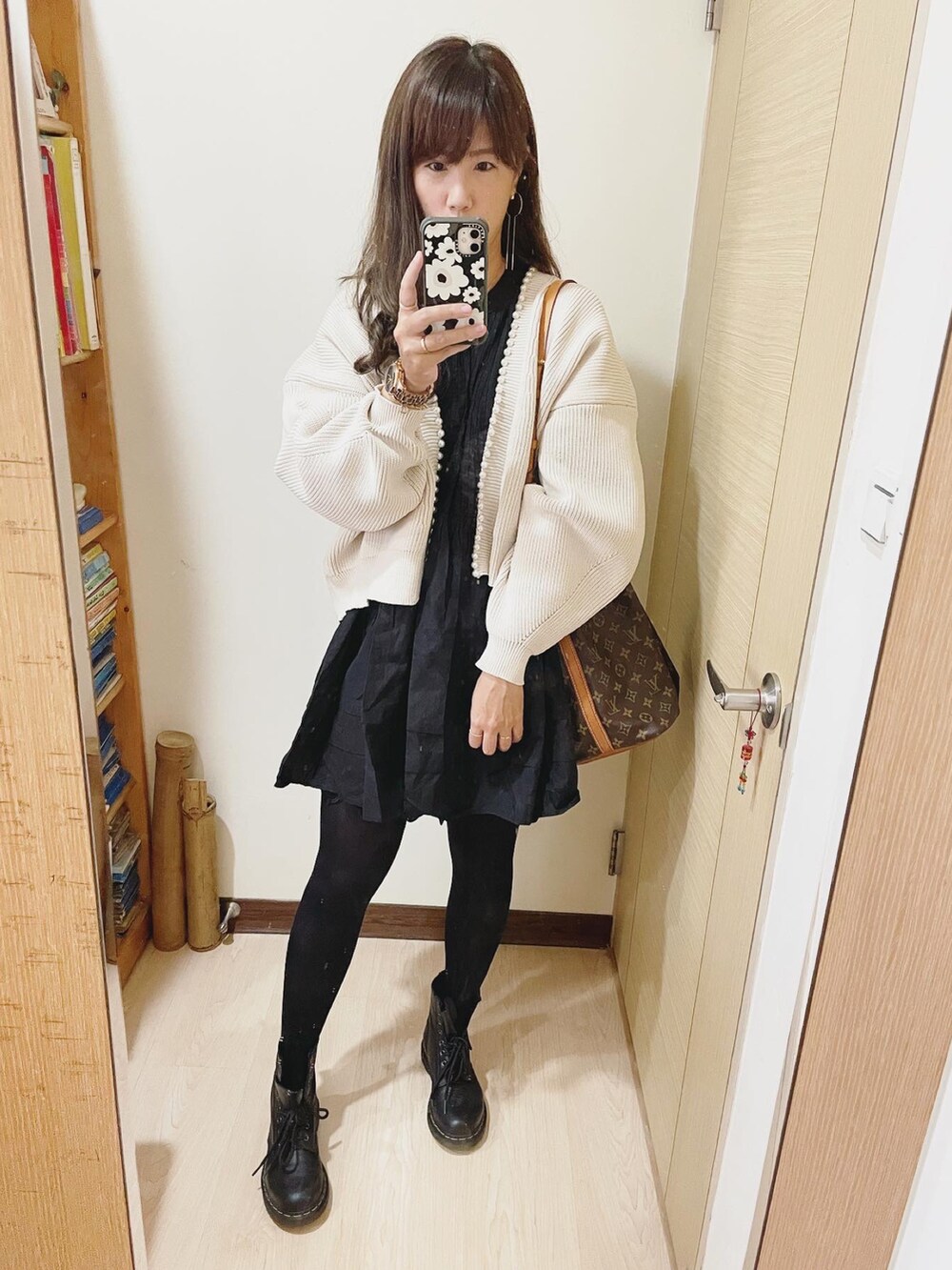 ブラック系のブーツ、ブラウン系のバッグ、ベージュ系のカーディガン/ボレロを着用したレディースの秋コーディネートの2枚目の写真